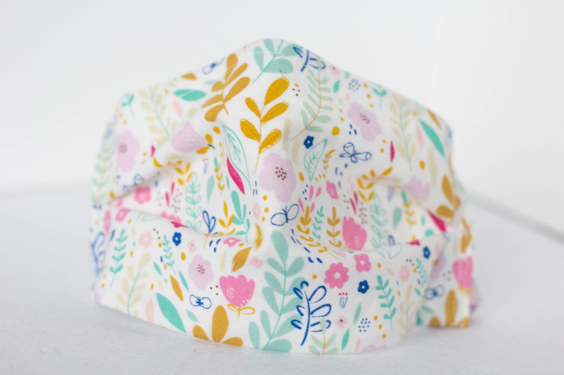 Floral face mask with flowers and butterflies.  Gold, teal, pink, blue, purple
